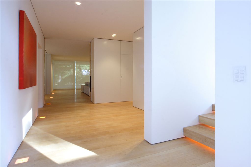 Central hallway opening to every room, with under-lit stairway on right.