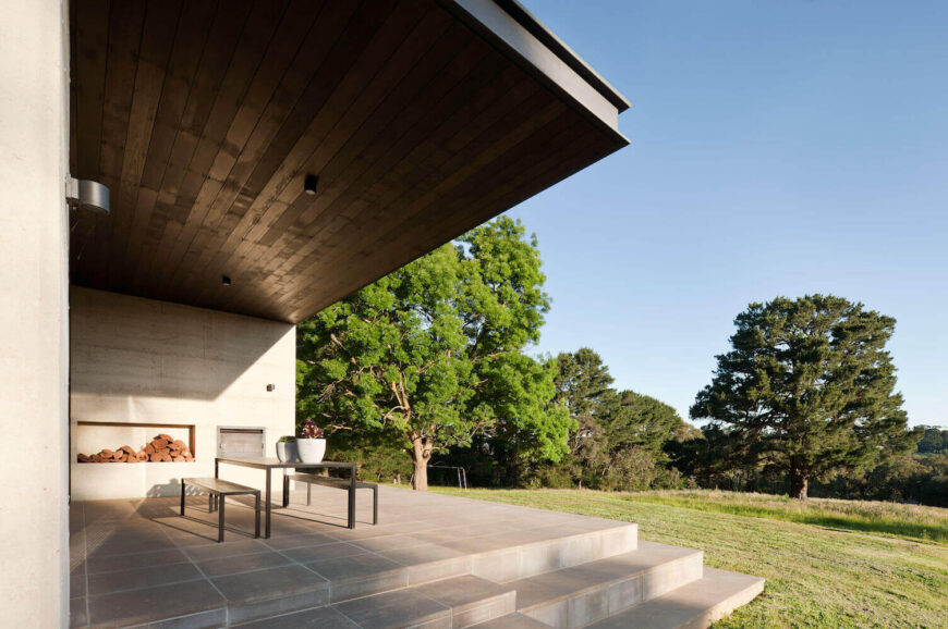 The dark wood eave can be seen in detail here, standing over the outdoor dining space with firewood store at left.