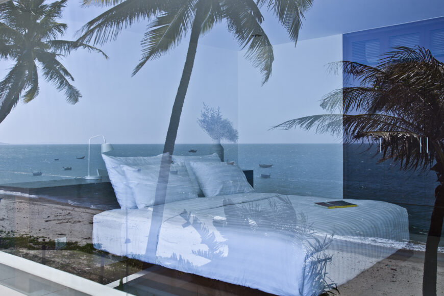 From outside, the cool glass reflects the ocean view guests enjoy from both inside and outside the home.