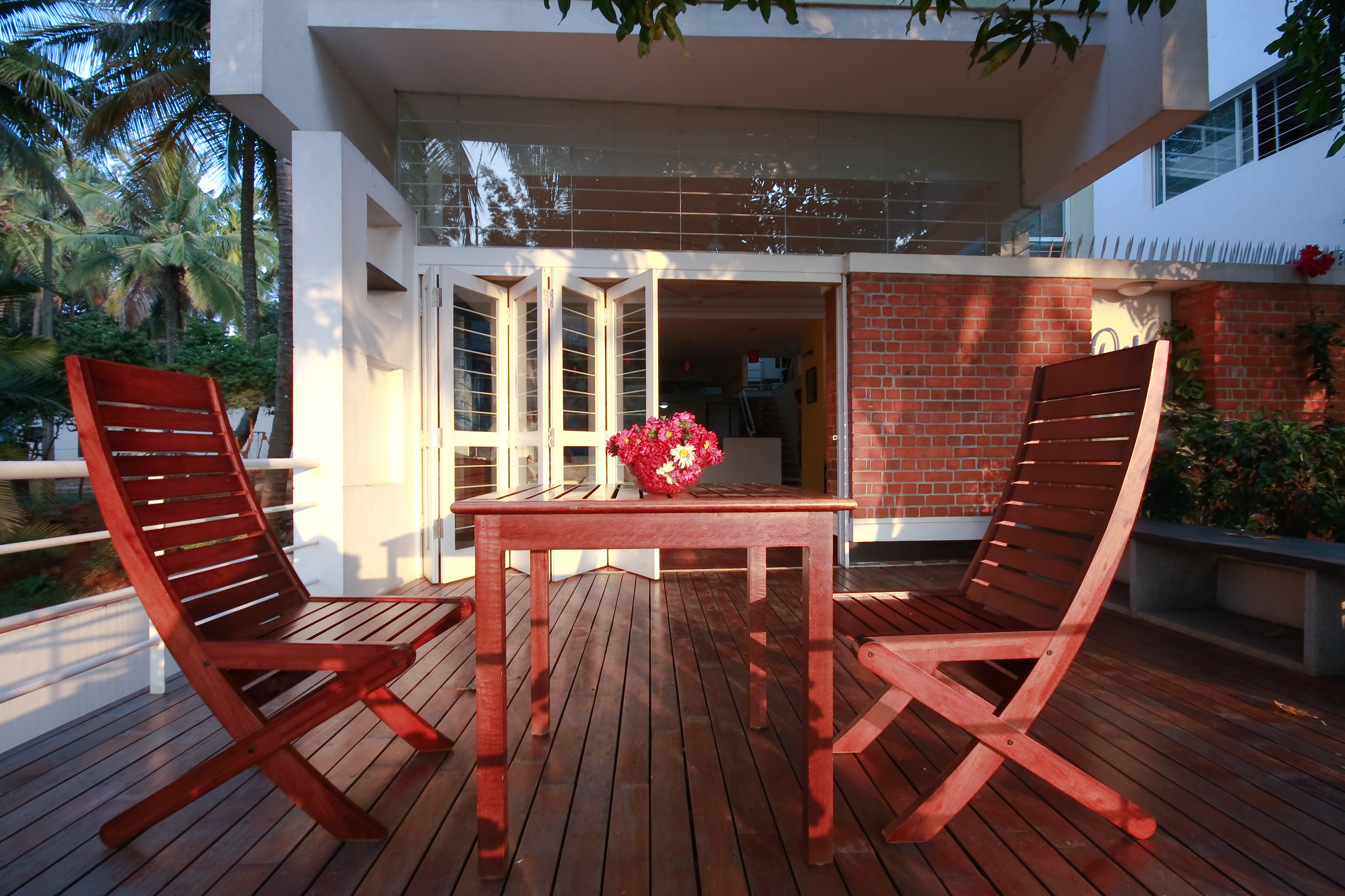 Here is the main patio as seen at dusk, with the expanse of glass upper wall clearly visible beneath the left balcony.