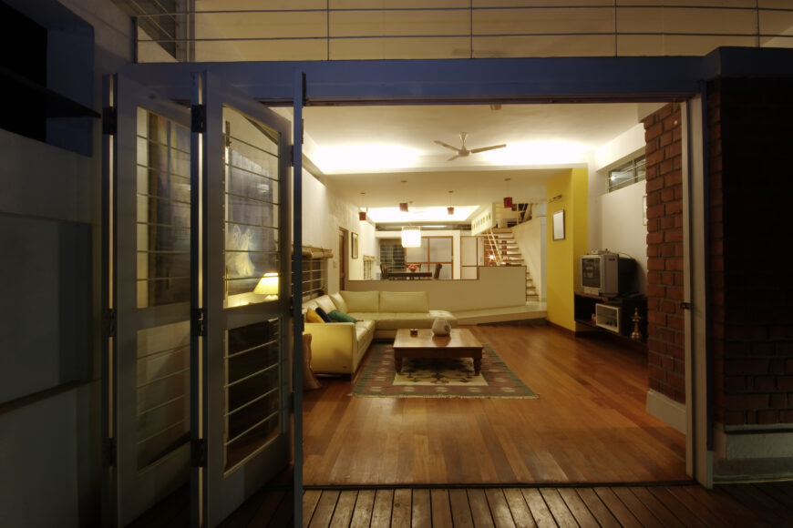 The lower living room as seen at night, with obscured overhead light glowing around the structure.