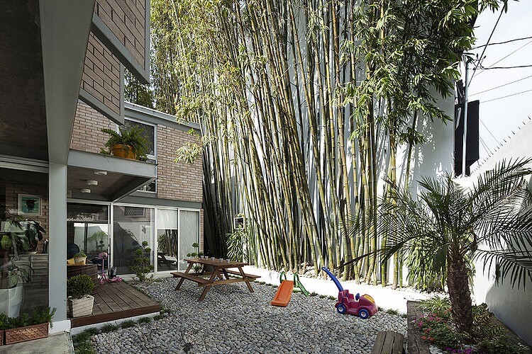 The bamboo perimeter creates the illusion of forested surroundings, offering pleasant greenery in view from every window. Rock garden area is flattened for socializing and play.