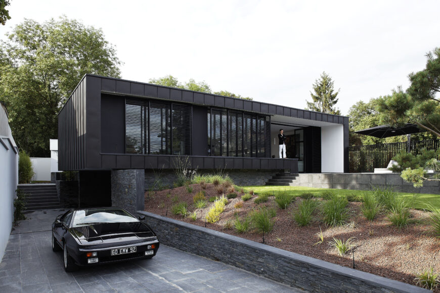 Final look at the front of the home, showcasing the lowered driveway with sheltered car port beneath the home.