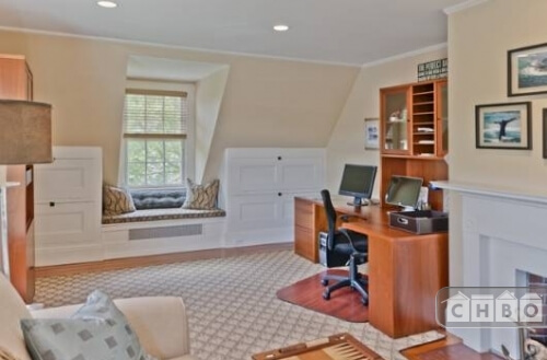 A small sitting room and study with a fireplace and window seat is a nice third floor retreat during the quiet hours of the day.