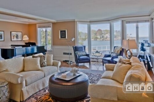 This living room is one of several, and contains the Steinway grand piano, a telescope and a view of the private dock. A circular ottoman sits between the two sofas and acts as a coffee table.