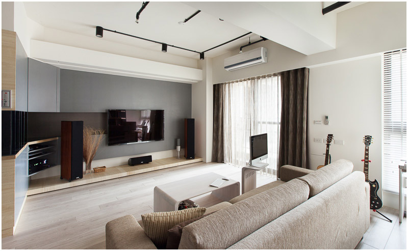 This view of the main sitting area in the living room in natural sunlight shows the lightly curving open shelving that leads into the back wall. The "hearth" is slightly raised from the floor.