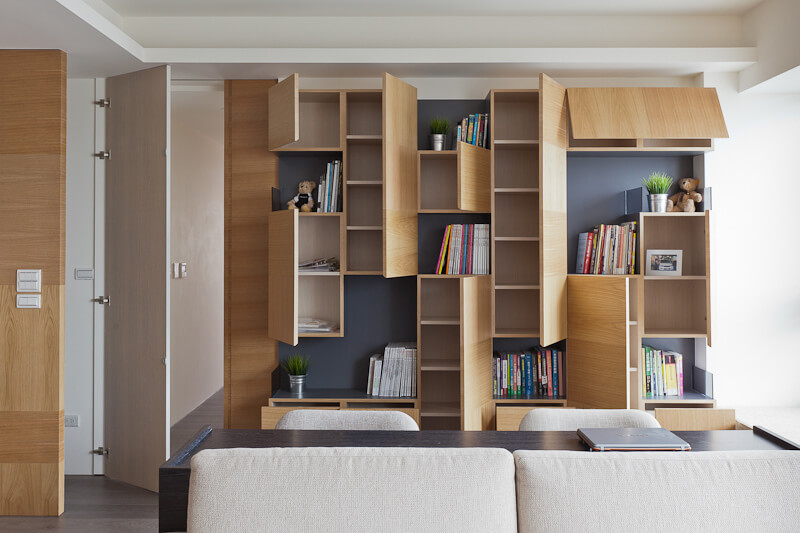 The cubic shelving opens in surprising ways, with panels both vertically and horizontally hinged, revealing interior storage.