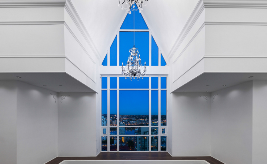 The third floor vaulted ceiling that started in the library on the first floor. This small balcony area opens into the primary bedroom while the expansive window gives a stunning view of the city and allows for plenty of bright light during the day.