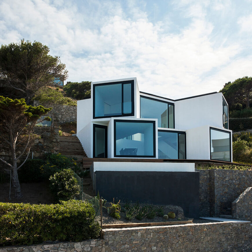 The rear of the home features the most stunning exterior, showing the cube-like structure of the home, with each section punctuated by an enormous panoramic window. The angle of each cube ensures that every window's view is unique.