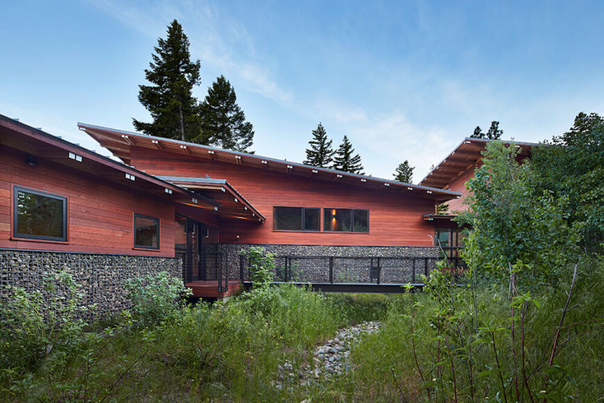 The beautiful front exterior of the retreat. The design was originally planned like a camp with three separate cabins for living, sleeping, and play. While planning the site, it became apparent that it would be more effective to create one structure with three distinct yet connected zones. Here you can better see each zone by the angle of the roof.