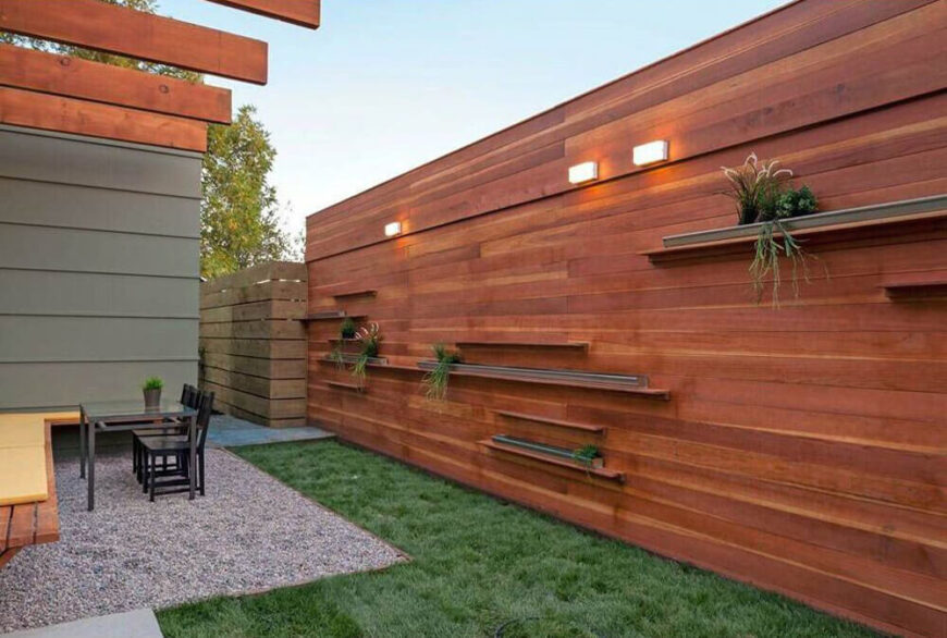 Here we see the massive natural wood wall, forming part of the continuous element that runs from the front approach to the back of the property. It features built-in shelving for slim container gardens here.