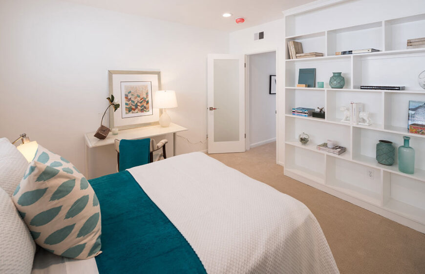 This bedroom is a great way to showcase the principle of arranging items on shelving. Not every shelf is full, but the items are varied in shape, color, and texture, creating that magazine-look that so many covet