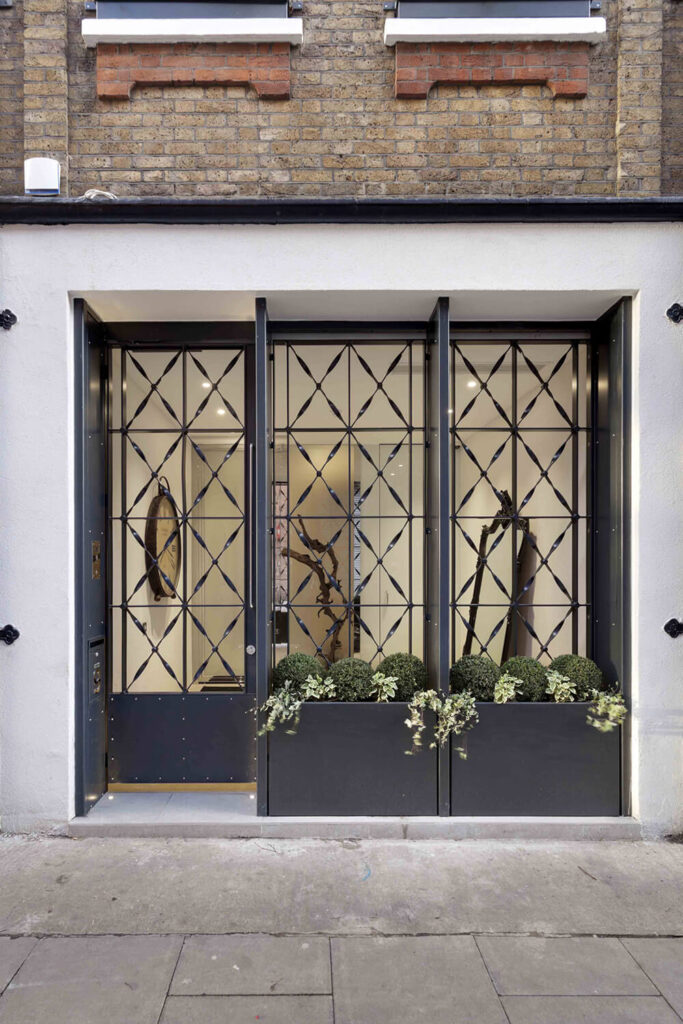 Here's a peek into the entryway, appearing at street level like the entrance to a classy shop or business. The decorative metal screen offers privacy and even space for a small garden.