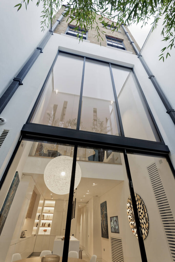 Here's the view into the massive, double height kitchen and dining room space, flooded with natural light through full height windows. Above, the more familiarly constructed floors are visible wrapped in brick.