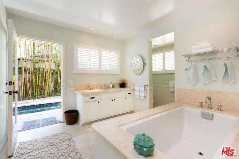 Example of a modern bathroom design from Vince Vaughn's home complete with peach accents seen from the countertop and bath tub, an entry to the shower area and carpeted main entrance providing easy access to the pool.