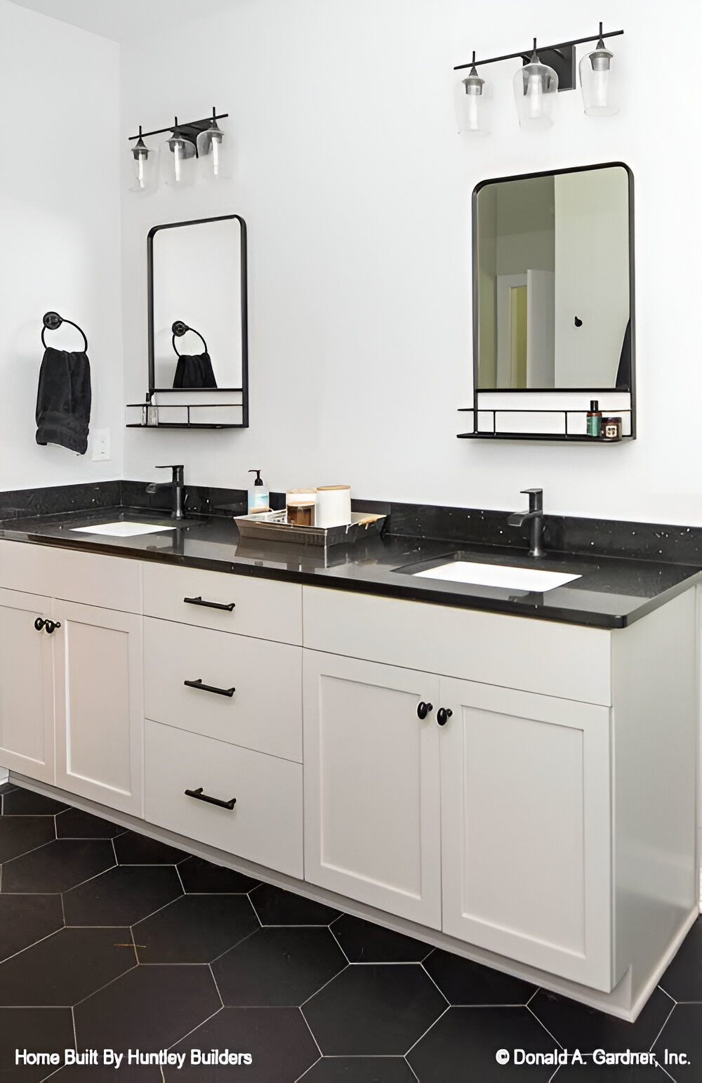 Primary bathroom with a dual sink vanity topped with framed mirrors and glass sconces.