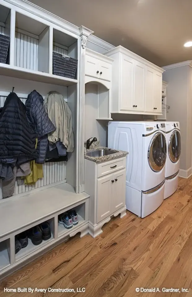 The utility room is equipped with built-in storage, a washstand, and a white front load washer and dryer.