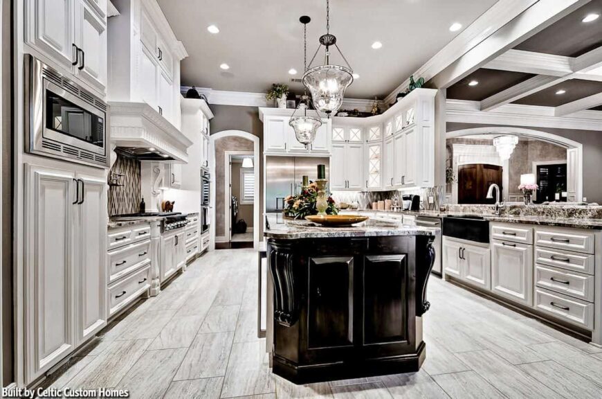 The kitchen is equipped with stainless steel appliances, a farmhouse sink, and a granite top island bar lit by glass pendants.