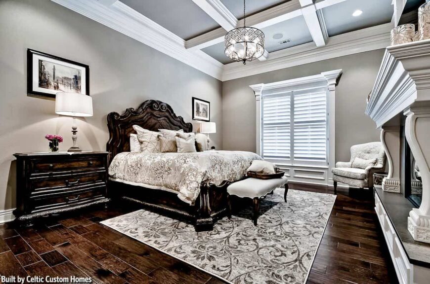 The primary bedroom has light gray walls and a coffered ceiling with hanging ornate drum chandelier.