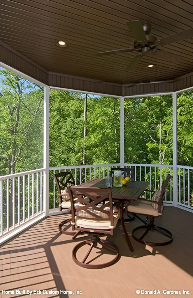 The screened porch is furnished with a wooden table and matching chairs topped with comfy cushions.