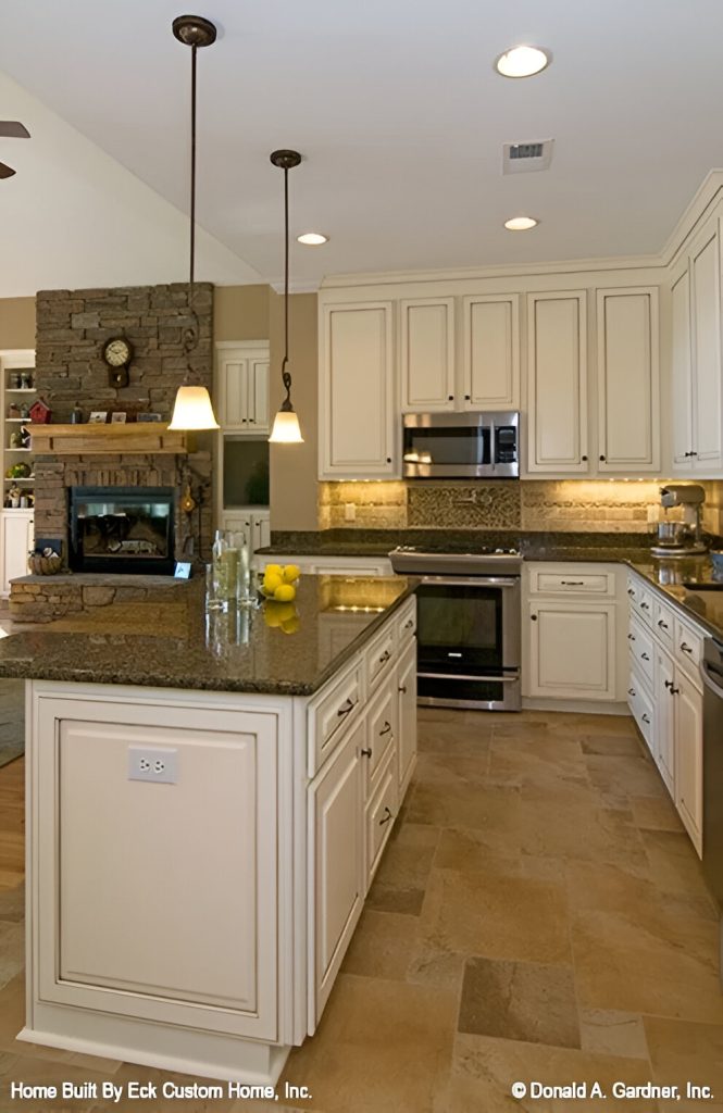 A pair of warm wrought iron sconces illuminate the center island bar sitting on a limestone flooring.