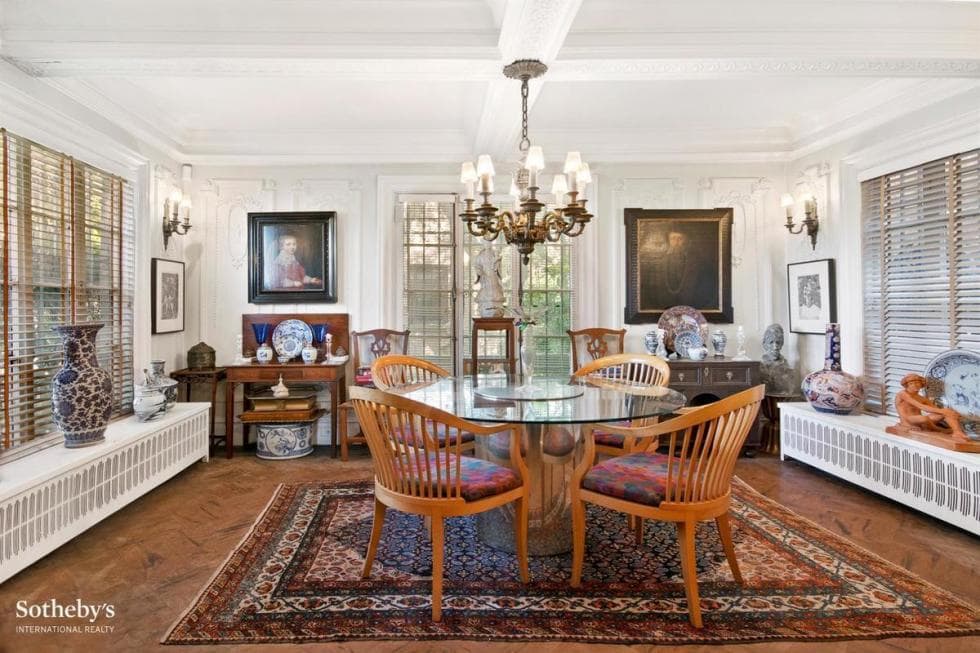 This is the dining room with a round glass-top dining table topped with a chandelier and adorned with various wall decorations. Image courtesy of Toptenrealestatedeals.com.