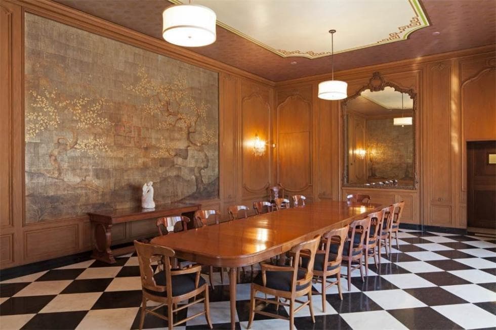 This is the formal dining room that has a large wooden dining table surrounded by wooden chairs that stand out against the black and white checkered flooring. Image courtesy of Toptenrealestatedeals.com.