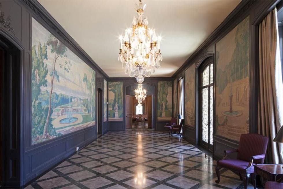 This is a look at the hallway with colorful murals on its walls and checkered pattern to its marble flooring that is complemented by the crystal chandelier. Image courtesy of Toptenrealestatedeals.com.