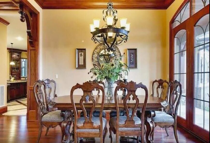 Wrought iron chandelier along with natural light from the massive windows brighten the dining room.