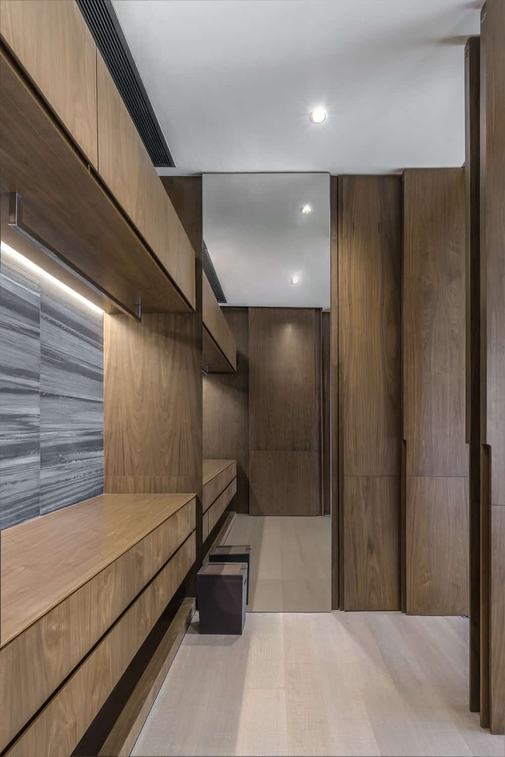 This is the bathroom that is dominated by wooden structures with cabinets and drawers.