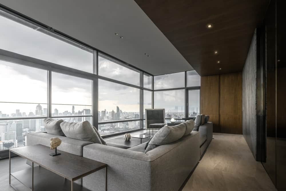 This is a view of the large and spacious living room showcasing the natural lights coming in from the glass walls.