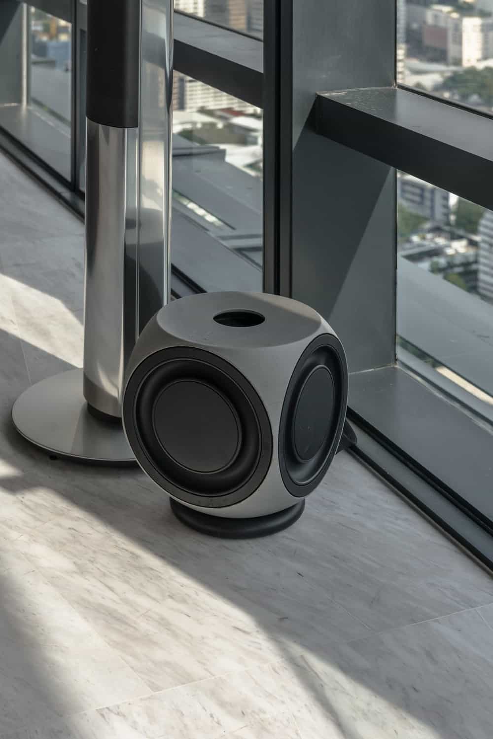 On one corner of the bedroom is this modern stereo speaker by the window.