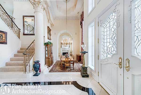 Foyer with white ornate door and a great view of the formal dining room with a display cabinet and wooden dining set on a classic area rug.