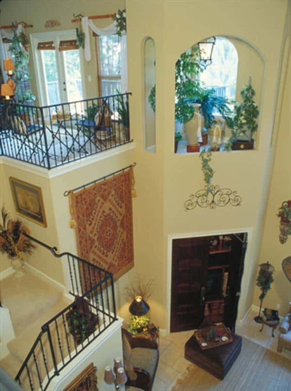 View of the family room from the balcony loft showing the entertainment center enclosed in a wooden double door.