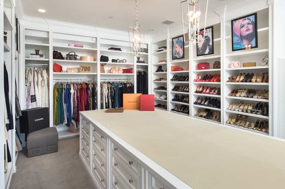 This is the walk-in closet with bright white wooden structures built into the walls surrounding the large island cabinet in the middle. Image courtesy of Toptenrealestatedeals.com.