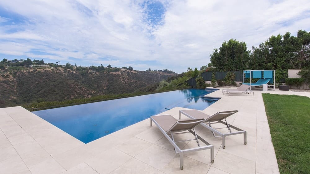 This is a closer look at the infinity-edged pool at the far end of the backyard with a sweeping view of the mountains. There's also a couple of lounge chairs at the side of the pool to better enjoy the scenery. Image courtesy of Toptenrealestatedeals.com.