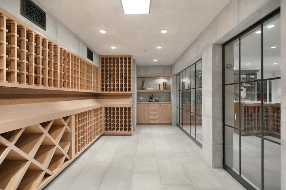 This is the 1,000-bottle wine cellar with large built-in wooden structures for wine storage. Across from these are a couple of French glass doors. Image courtesy of Toptenrealestatedeals.com.