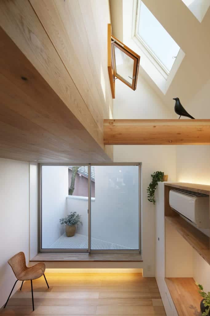 This is a look at the upper level of the house with skylights that bring in natural lighting for the white walls and wooden elements.