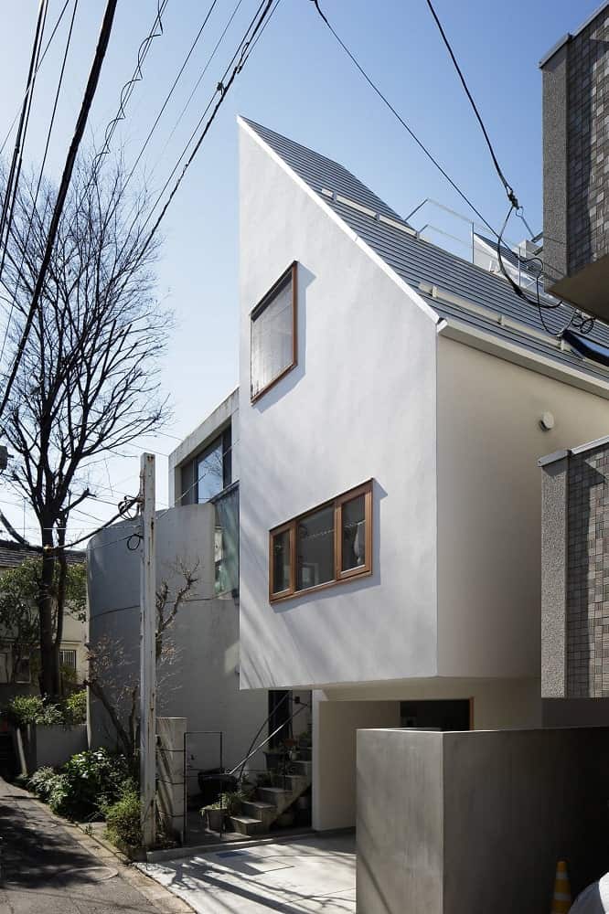 This angled view of the front of the house showcases the unique shape of the house along with its roof.