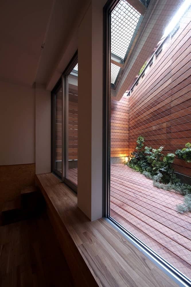 After climbing the stairs on the side of the car port, you come to this entrance with a wooden deck floor to match the walls topped with skylights.