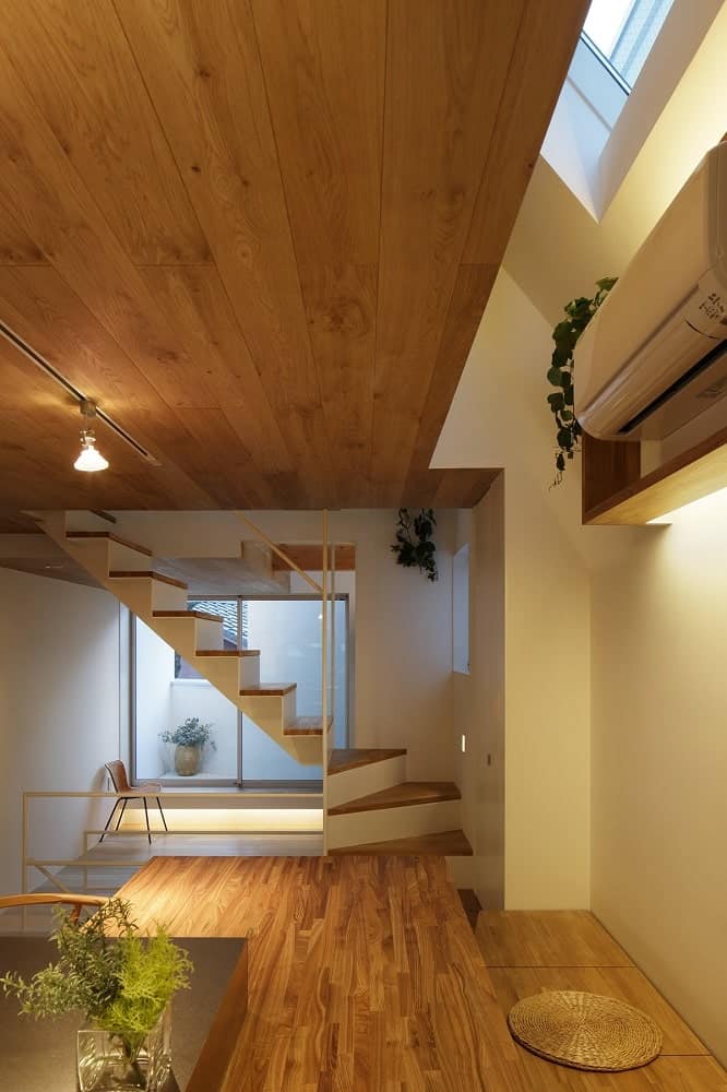 This is a look at the stairs and ceiling from the vantage of the built-in wooden table at the kitchen with matching tones.