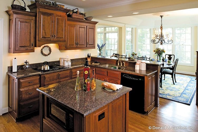 Eat-in kitchen with granite countertops, wooden cabinetry, black appliances, and a small center island.