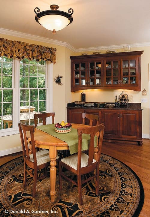 Breakfast room with buffet cabinet, round dining table, a classic area rug, and a glass dome pendant.