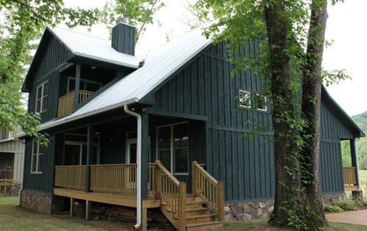 Rear exterior view with gable roofs, board and batten siding, and a covered porch.