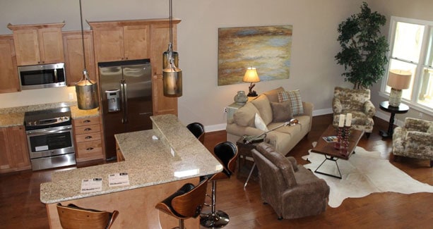 Open layout view of the living room and kitchen with natural hardwood flooring.