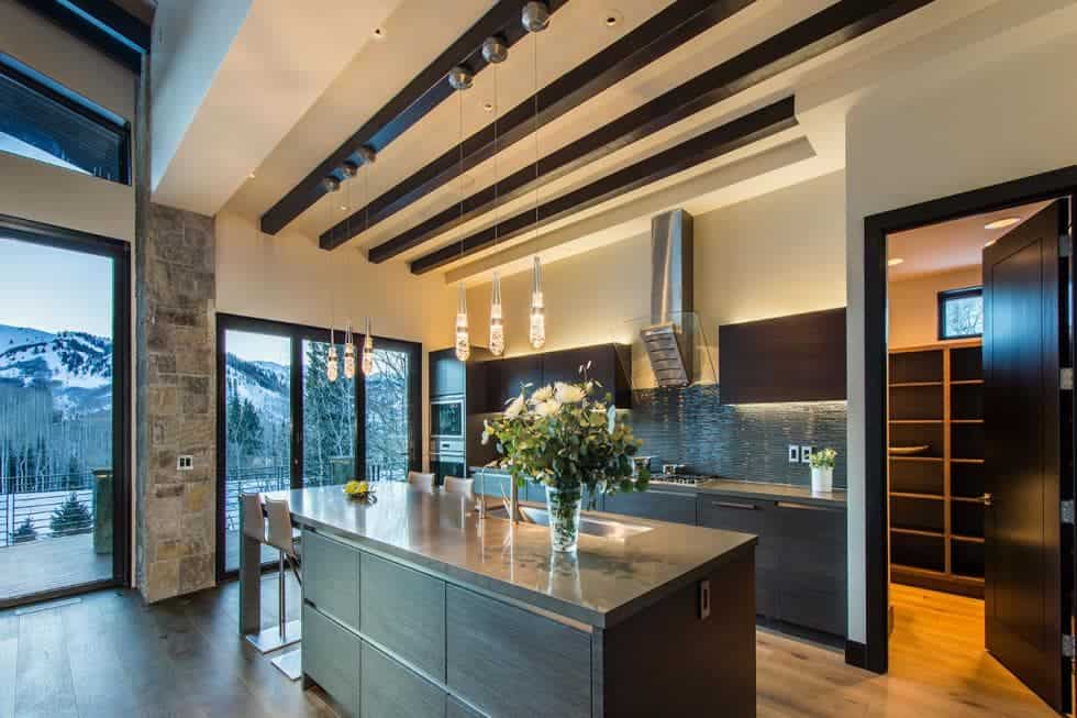 This is the spacious kitchen with a beamed ceiling above the dark cabinetry of the kicthen island to match those lining the walls. Image courtesy of Toptenrealestatedeals.com.