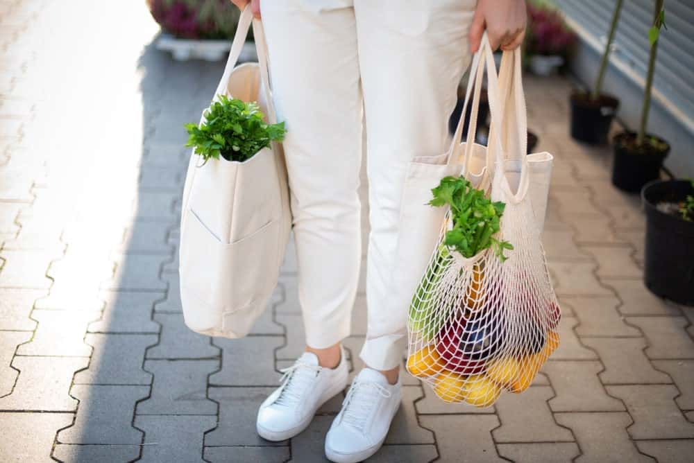 A woman carrying her groceries in eco-friendly reusable bags.