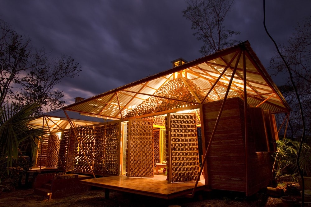 This is a nighttime view of the house that has swiveling exterior wall panels that are made of mounted pieces of bamboo that can let in light.