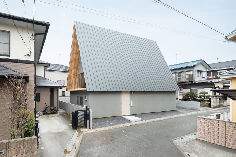 This is a side of the house that showcases more of the tall A-frame roof with a consistent light gray tone to the roof and exterior wall.