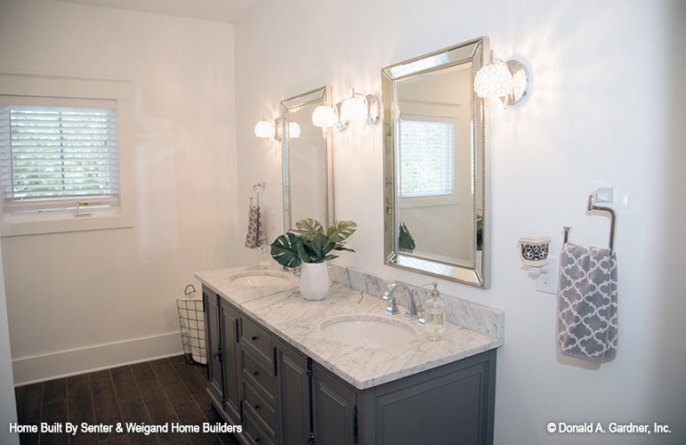 The primary bathroom features a gray vanity with double sinks, marble countertop, and chrome framed mirrors.